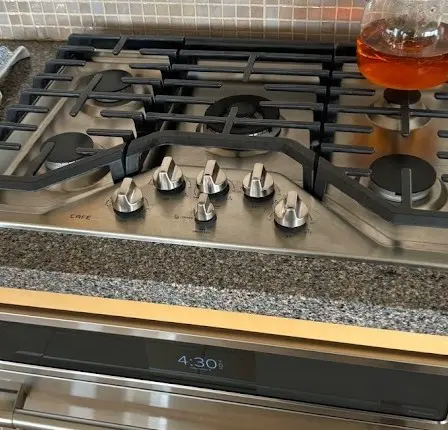Estufa de gas de acero inoxidable con perillas de control y una superficie limpia, ideal para una cocina funcional y bien mantenida.