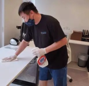 Empleado limpiando superficies de oficina, servicio de limpieza comercial y residencial en Los Ángeles