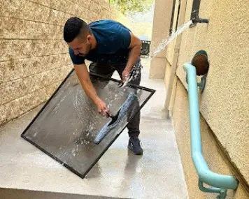 Empleado profesional de limpieza, limpiando una ventana