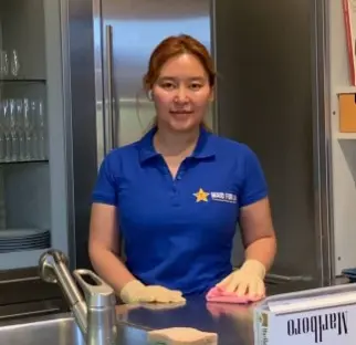 Trabajadora profesional de limpieza limpiando la cocina, servicio de limpieza de casas en Los Ángeles