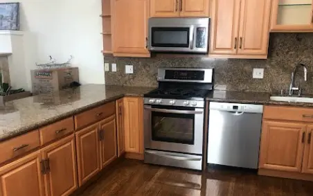 Cocina impecable con electrodomésticos de acero inoxidable y encimeras limpias, resultado del servicio de una compañía de limpieza de casas en San Francisco.