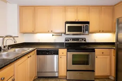 Cocina moderna y limpia con electrodomésticos de acero inoxidable y encimeras de granito, resultado del servicio de North Shore Cleaning