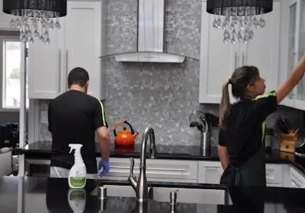 Equipo de limpieza profesional trabajando en una cocina moderna, parte del servicio de limpieza de casas en San Francisco.