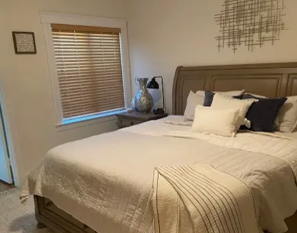 Dormitorio limpio y organizado con ropa de cama elegante, resultado del servicio profesional de una compañía de limpieza de casas en San Francisco.