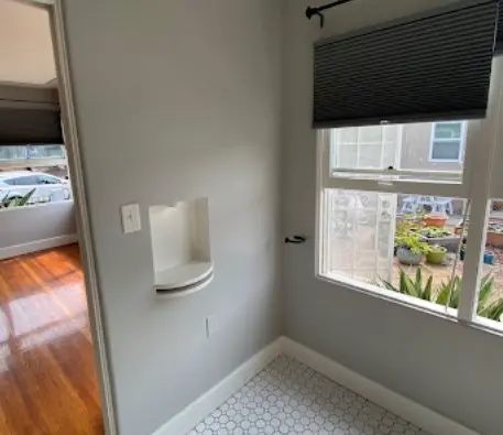 Habitación luminosa y ordenada con piso hexagonal limpio y ventana que da al exterior