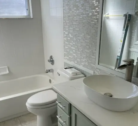 Baño bien mantenido en Orlando con lavabo moderno y ducha de cristal, ejemplificando la calidad y detalle de la limpieza de casas en la región, con superficies pulidas y un ambiente higiénico